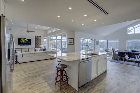 View from kitchen to DR, LR, canal and pool