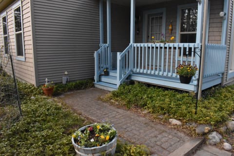 Secure covered front porch provides convenient entryway and shaded seating.