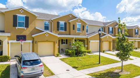 Cheerful townhouse row with warm yellow exteriors and black shutters-bright curb appeal in a friendly neighborhood.