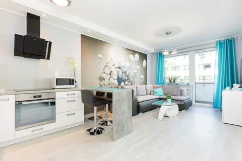 A bright living room with a gray sofa, glass coffee table, and modern decor, providing a chic space for relaxation.