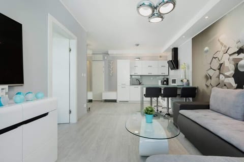 A cozy living room with blue curtains, gray sofas, and decorative elements, offering a calm and inviting atmosphere.