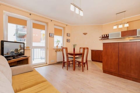 Another view of a cozy living room with sofas and a table. Large glass doors lead to an outdoor area.