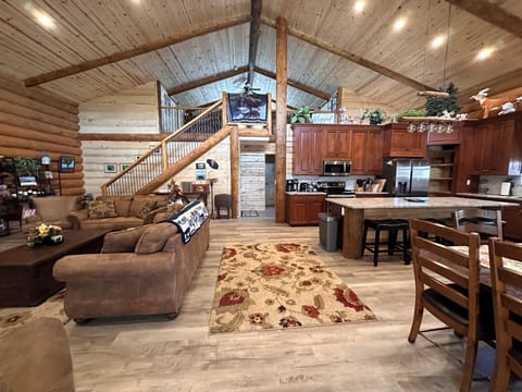 Wide view of living room, dining area, kitchen, and loft area.