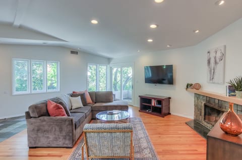 The living area features high ceilings, decorative fireplace, 55" TV with Cable 