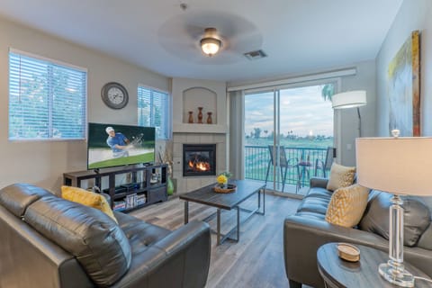 The great room in SUPERSTITION LAKES MANOR has a gas fireplace, large TV and spectacular views of the public golf course.