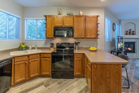 Corner windows add natural light to open and completely stocked kitchen.