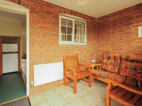 Light and airy tile-floored entrance porch with seating | Sweet Coppin - The Old Kennels Holidays, Ledbury
