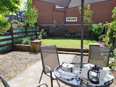 Enclosed lawned garden with sitting-out area and garden furniture | Magnolia Lodge, Sheringham