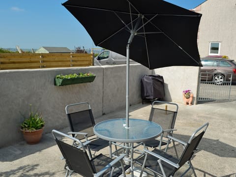 Outdoor sitting/dining area | Ty Main Cottage, Newborough, near Llangefni