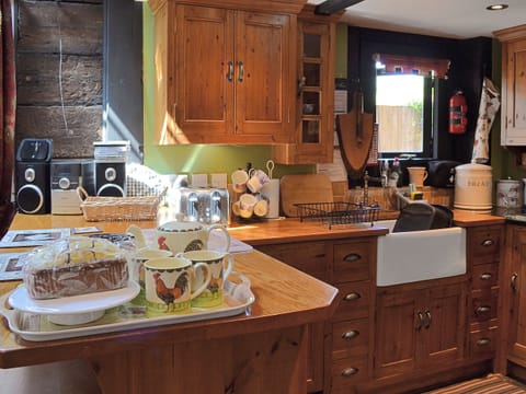 The property features a traditional handmade kitchen with wood topped breakfast bar | Brook Barn - Brook and Meadow Barns, Shobley, Ringwood
