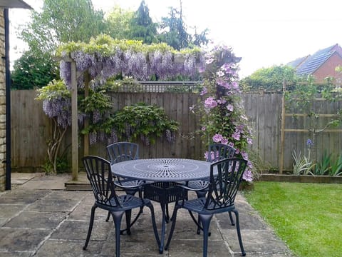 Sunny paved patio with furniture | Russet Cottage, Moreton-in-Marsh