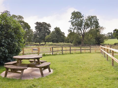 Lawned garden area with outdoor furniture on a paved patio | Churchill Cottage - Round Chimneys Farm, Glanvilles Wootton, near Sherborne