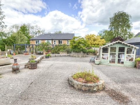 Patio area with summerhouse and cottage in the background | Hadrian’s Garden Villa, Henshaw, near Haltwhistle