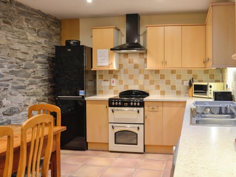 Traditional stone feature wall in dining area of kitchen | Ty Hir - Bwlchgwyn Equestrian Holidays, Arthog, near Fairbourne