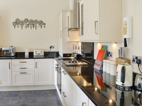 Well-equipped fitted kitchen with convenient dining area | Sgubor Ucha, Llanrhychwyn, Trefriw