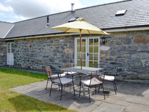 Paved patio area within enclosed rear garden | Sgubor Ucha, Llanrhychwyn, Trefriw