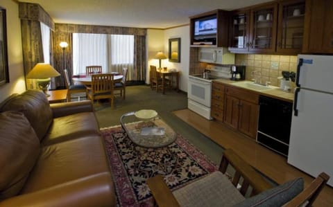 Full kitchen with sleeper sofa, dining table, hot tub on porch.