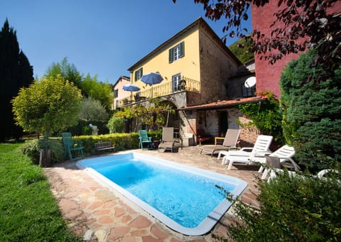 View from garden of house and balcony, pool and sitting area and loggia