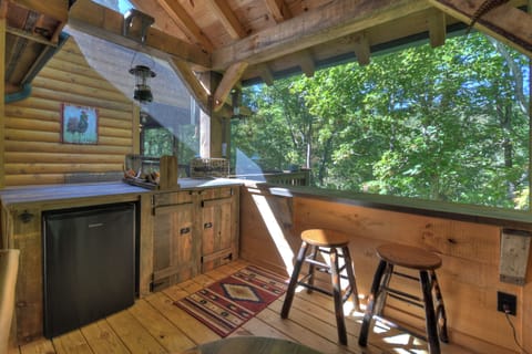 Living area on the covered porch with a tv (seasonal use) and a seasonal gas log fireplace!