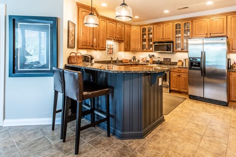 Tiled backsplash, under-counter lighting, bar seating with granite countertops.