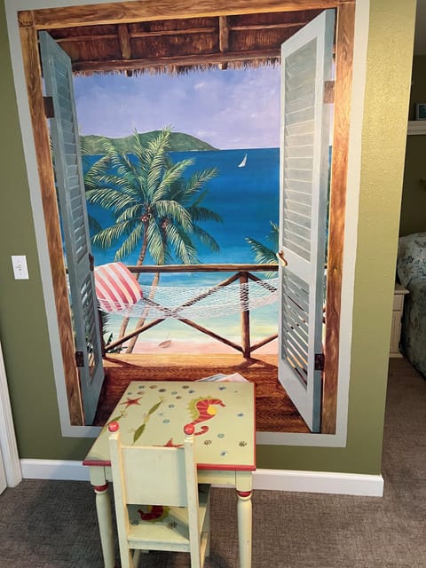 Beach theme wall and childs table carrying on the tiki hut theme.