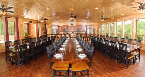 Massive dining area with three long dining tables and many, many chairs.