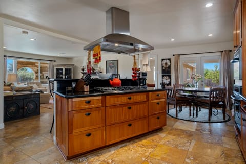 Kitchen & bistro nook w/granite counters, travertine floor & open to living room
