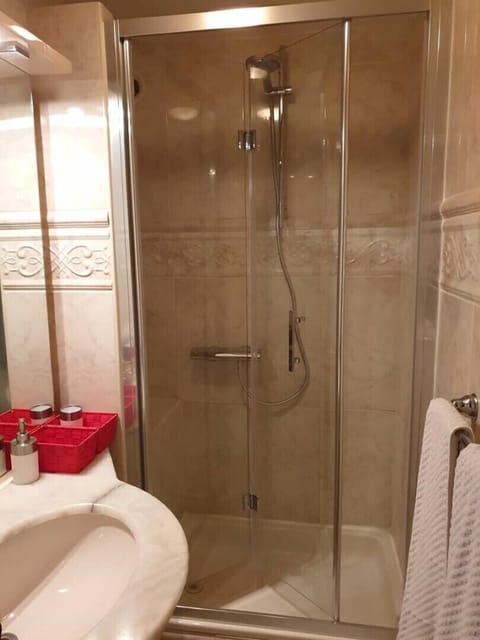 the luxurious marbled shower cabin  with  glass doors .