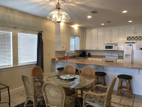Full kitchen with bar seating and dinning room table. 