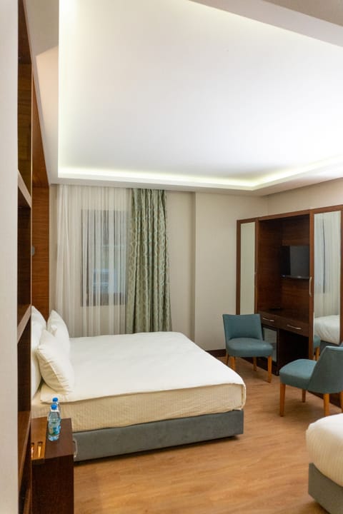 Deluxe Triple Room | Minibar, in-room safe, desk, laptop workspace