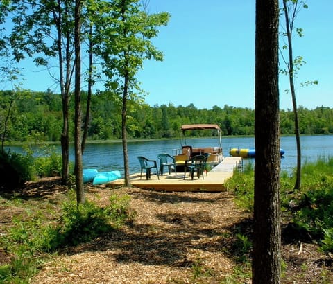 Private water frontage with fire pit, pontoon boat and kayaks.