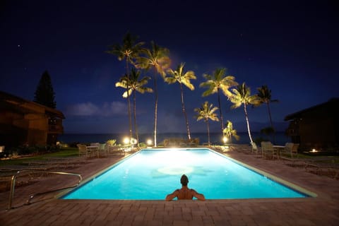 The beautifully lit pool at night.