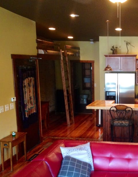 Two twin lofts style beds located above a desk in a hallway to bath/bedroom
