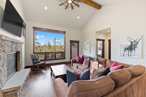 Sink into the plush sectional and enjoy your perfect mountain retreat with exposed beams, stone fireplace, and forest views.
