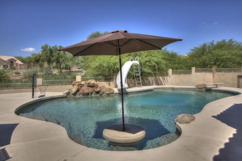Heated, salt water, pebble tech pool with swim-up-table, slide and diving board