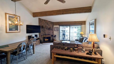 Living room with sofa bed, wood fireplace, and balcony w/ propane BBQ grill