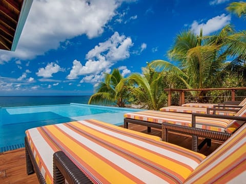 Our infinity edge pool creates a seamless horizon where crystal water meets the deep blue sea. It’s the ultimate spot to soak in the sun while the Caribbean feels close enough to touch. 🌊✨