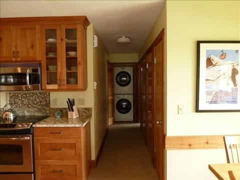 Kitchen and hallway with laundry closet between two bedrooms.