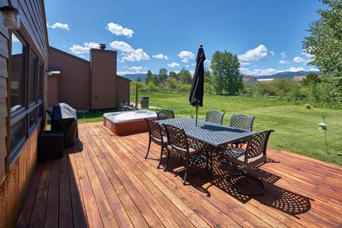 Hot tub, grill, dining table & umbrella overlooking open space