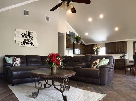 Living room includes leather sectional plus flat screen TV