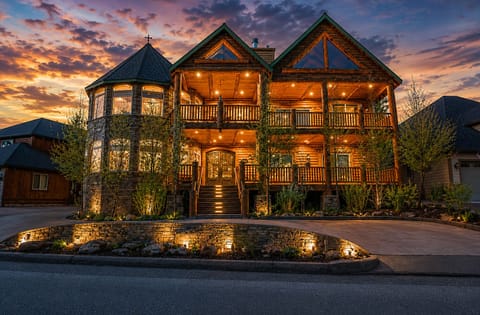 A grand mountain retreat with glowing balconies, stonework, and timeless charm!