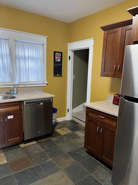 Kitchen has quartz countertop, stainless steel appliances, & heated slate floor.