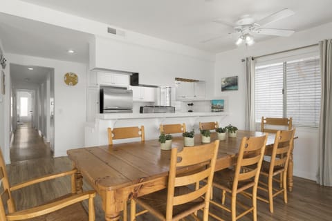 Large family dining table sits adjacent to the kitchen on one side and living room on the other.
                