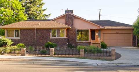 Rock house has a one car garage with a long concrete driveway