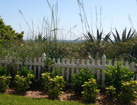 Unit #101 private landscaped yard with ocean in the background