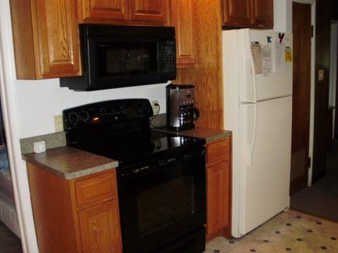 Kitchen shows Stove/oven and microwave/convection oven. Coffee pot.