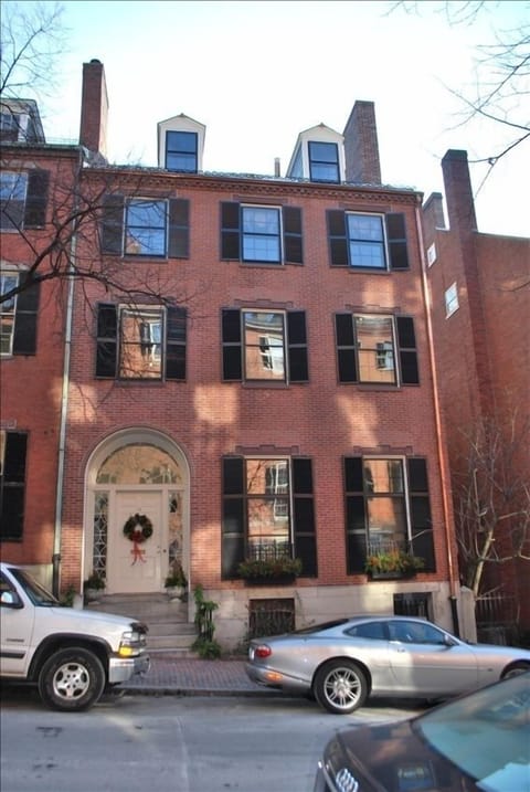 Full view of house from gas lit street. Garden gate entrance on right.