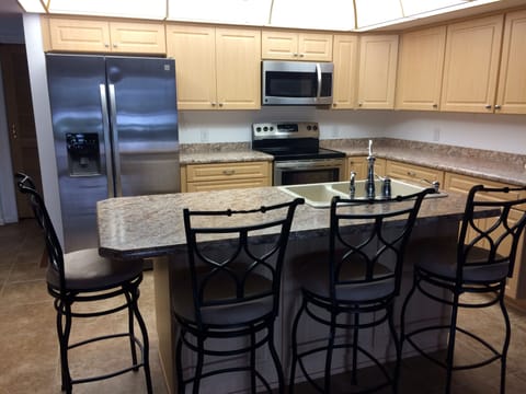 The kitchen has New Stainless Steel appliances and Cabinets with a breakfast bar