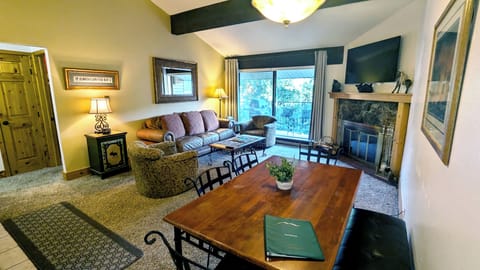 Living room with sofa bed, wood fireplace, and balcony w/ propane BBQ grill