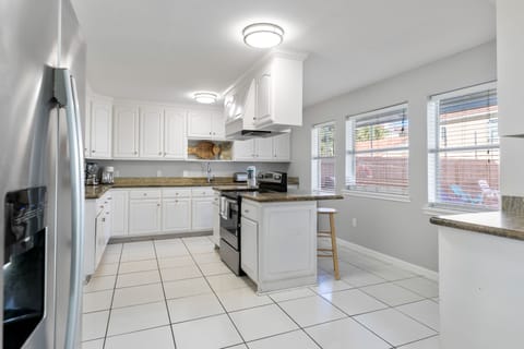 Large kitchen with additional bar seating and stainless steel appliances